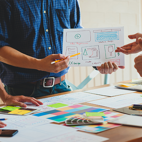 A website developer guides a web designer on how to make a website responsive <br><br>